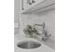 Close up of modern faucet, plant, and decor on the wet bar's granite countertop and tile backsplash at 4905 Ivercroft Pl, Fuquay Varina, NC 27526