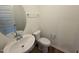 Stylish half-bathroom with a vessel sink, round mirror, and modern fixtures at 507 Eastwood St, Durham, NC 27704