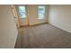 Bedroom with neutral carpet, two windows, and closet space at 507 Eastwood St, Durham, NC 27704