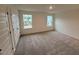 Large bedroom with two windows and plush carpeting at 507 Eastwood St, Durham, NC 27704