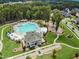 Aerial view of community clubhouse and pool surrounded by lush greenery and walking paths at 521 Morning Oaks Dr, Holly Springs, NC 27540
