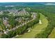 Aerial view showcasing the golf course community, featuring a lush course and cozy homes at 521 Morning Oaks Dr, Holly Springs, NC 27540