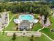 Aerial view of the community pool area showcasing the pool, clubhouse, and surrounding landscaping at 521 Morning Oaks Dr, Holly Springs, NC 27540
