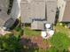 Aerial view of landscaped backyard with patio, umbrellas, and manicured lawn at 521 Morning Oaks Dr, Holly Springs, NC 27540
