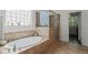 Bathroom with soaking tub, glass enclosed shower, and decorative tile at 521 Morning Oaks Dr, Holly Springs, NC 27540