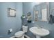 Stylish powder room featuring elegant blue walls, modern fixtures, and tasteful decor, adding a touch of sophistication at 521 Morning Oaks Dr, Holly Springs, NC 27540