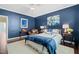 A well-decorated bedroom features a blue accent wall, decorative lamps, and stylish artwork at 521 Morning Oaks Dr, Holly Springs, NC 27540