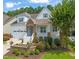 Charming two-story home featuring a welcoming front porch, well-manicured landscaping, and an attached two-car garage at 521 Morning Oaks Dr, Holly Springs, NC 27540