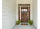 Charming front door with detailed trim and potted plants, creating a warm welcome at 521 Morning Oaks Dr, Holly Springs, NC 27540