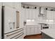 Modern kitchen showcases white cabinets, stainless steel appliances, and granite countertops for a sleek and stylish culinary space at 521 Morning Oaks Dr, Holly Springs, NC 27540
