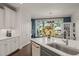 This beautiful kitchen features an island with seating, white cabinets, and a sink with granite countertops at 521 Morning Oaks Dr, Holly Springs, NC 27540