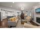 Spacious open-concept living area with a fireplace, elegant furnishings, and seamless flow into the kitchen, perfect for modern living at 521 Morning Oaks Dr, Holly Springs, NC 27540