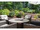 Serene patio area with comfortable seating, a fire pit table, and colorful landscaping, perfect for outdoor gatherings at 521 Morning Oaks Dr, Holly Springs, NC 27540