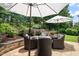 Inviting stone patio with comfortable seating, a fire pit, and lush landscaping, ideal for outdoor relaxation at 521 Morning Oaks Dr, Holly Springs, NC 27540