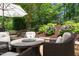 Charming patio features a fire pit table, wicker chairs, and beautiful landscaping, creating a cozy outdoor retreat at 521 Morning Oaks Dr, Holly Springs, NC 27540