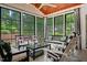 Relaxing sunroom with abundant natural light, comfortable seating, and a peaceful view of the surrounding trees and yard at 521 Morning Oaks Dr, Holly Springs, NC 27540