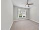 Neutral bedroom features plush carpet, a ceiling fan, and a bright window with blinds at 537 Bramble Ln, Clayton, NC 27527