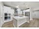 Gourmet kitchen with quartz island, stainless appliances, and white cabinets at 537 Bramble Ln, Clayton, NC 27527