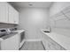 Well-lit laundry room featuring patterned floors, a stainless steel sink, and white cabinets at 537 Bramble Ln, Clayton, NC 27527