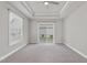 Large bedroom featuring a tray ceiling, plush carpet, and sliding door to the backyard at 537 Bramble Ln, Clayton, NC 27527