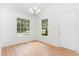 Bright dining area with hardwood floors, large windows, and a modern chandelier, creating a welcoming space at 5429 Fortunes Ridge Dr, Durham, NC 27713