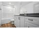 Modern bathroom with white cabinets, dark countertops, and a tub/shower combination at 5500 Lake Wendell Rd, Zebulon, NC 27597