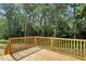 This wood deck offers scenic views of the surrounding lush greenery and tall trees at 5500 Lake Wendell Rd, Zebulon, NC 27597