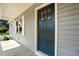 Close-up of a dark teal front door with windows and gray siding at 5500 Lake Wendell Rd, Zebulon, NC 27597