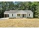 Charming single-story home featuring light gray siding and a cozy front porch at 5500 Lake Wendell Rd, Zebulon, NC 27597