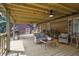 Spacious wooden back porch has seating, a ceiling fan, and room for relaxation and entertaining guests at 5593 Leon Rd, Nashville, NC 27856