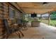 Wooden back porch has seating, a ceiling fan, and room for lounging in a home at 5593 Leon Rd, Nashville, NC 27856