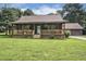 Charming log cabin with a cozy front porch, lush lawn, and a detached garage at 5593 Leon Rd, Nashville, NC 27856