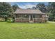 Rustic log home featuring a covered front porch, natural landscaping, and a tranquil setting at 5593 Leon Rd, Nashville, NC 27856