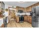 This kitchen boasts wooden cabinets, stainless steel appliances, and tile backsplash at 5593 Leon Rd, Nashville, NC 27856