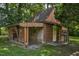 Rustic log cabin outbuilding with covered storage and garden space at 5593 Leon Rd, Nashville, NC 27856