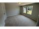 A cozy bedroom featuring neutral walls, plush carpeting, and two windows that flood the room with natural light at 57 Blanton Ct, Lillington, NC 27546
