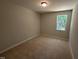 Neutral bedroom with tan carpet and a bright single window at 57 Blanton Ct, Lillington, NC 27546