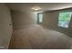 Bright, carpeted bedroom with two large windows at 57 Blanton Ct, Lillington, NC 27546