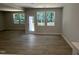 Open living room with wood floors, and many windows with peaceful outdoor views at 57 Blanton Ct, Lillington, NC 27546