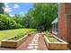 Expansive backyard with lush lawn, garden beds, and a screened porch at 5833 Dahlberg Dr, Raleigh, NC 27603