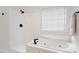 Bright bathroom showcases a pristine white tiled shower and a luxurious soaking tub with a black fixture at 5833 Dahlberg Dr, Raleigh, NC 27603