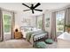 Cozy bedroom features three windows, a comfortable bed, decorative pillows, and stylish decor at 5833 Dahlberg Dr, Raleigh, NC 27603