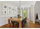 Elegant dining room with modern lighting, hardwood floors, and a gallery wall of Gathering photos at 5833 Dahlberg Dr, Raleigh, NC 27603