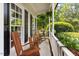 Relaxing front porch with wooden rocking chairs and a view of the lush green landscape at 5833 Dahlberg Dr, Raleigh, NC 27603