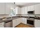 Well-lit kitchen featuring stainless appliances, granite countertops, and ample cabinetry at 5833 Dahlberg Dr, Raleigh, NC 27603