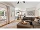 Open-concept living room featuring a gray sectional and a view into a white-cabinet kitchen at 5833 Dahlberg Dr, Raleigh, NC 27603
