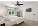 Spacious bedroom with a ceiling fan, natural light, and a glimpse into the en suite bath at 5833 Dahlberg Dr, Raleigh, NC 27603