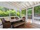 Inviting screened porch with comfortable seating, a dining table, and views of the green backyard at 5833 Dahlberg Dr, Raleigh, NC 27603