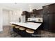 Modern kitchen with dark cabinets, stainless steel appliances, a large island, and bar stool seating at 59 Curling Creek Dr # I285, Clayton, NC 27527