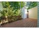 A wood back deck adjoins to outbuildings, surrounded by lush trees and foliage, creating a private outdoor retreat at 6051 Epping Forest Dr, Raleigh, NC 27613